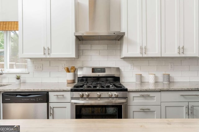 936 Ormewood Ter SE, Atlanta, GA 30316 - kitchen featuring appliances with stainless steel finishes, wall chimney range hood, white cabinetry, and decorative backsplash