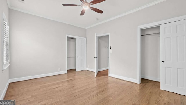 3532 Paces Pl NW, Atlanta, GA 30327 - unfurnished bedroom featuring two closets, wood finished floors, ornamental molding, and a ceiling fan