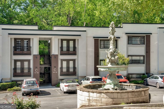 1445 Monroe Dr NE Unit C13, Atlanta, GA 30324 - view of front of property with french doors, stucco siding, and uncovered parking
