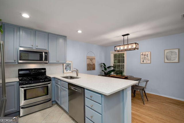 1445 Monroe Dr NE Unit C13, Atlanta, GA 30324 - kitchen with stainless steel appliances, a peninsula, light countertops, decorative backsplash, and gray cabinetry