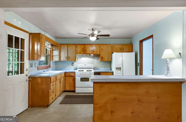 511 Oakview Rd, Decatur, GA 30030 - kitchen featuring white appliances, under cabinet range hood, brown cabinets, a sink, and tasteful backsplash