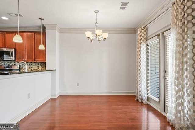 1199 Lavista Rd NE, Atlanta, GA 30324 - kitchen with appliances with stainless steel finishes, dark countertops, dark wood finished floors, plenty of natural light, and crown molding