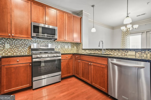 1199 Lavista Rd NE, Atlanta, GA 30324 - kitchen with appliances with stainless steel finishes, a sink, crown molding, dark stone countertops, and light wood-style flooring