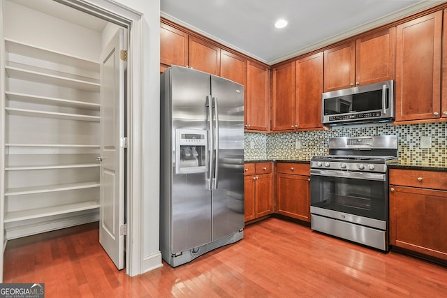1199 Lavista Rd NE, Atlanta, GA 30324 - kitchen featuring appliances with stainless steel finishes, light wood-style floors, decorative backsplash, and brown cabinetry