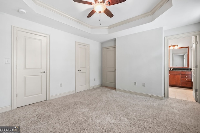1199 Lavista Rd NE, Atlanta, GA 30324 - unfurnished bedroom featuring light colored carpet, a tray ceiling, crown molding, baseboards, and connected bathroom