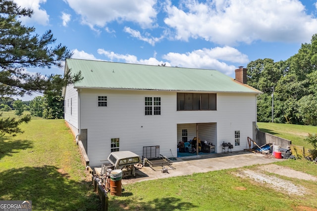 653 Fort Lamar Rd, Commerce, GA 30530 - back of house featuring a patio, a chimney, a lawn, and metal roof