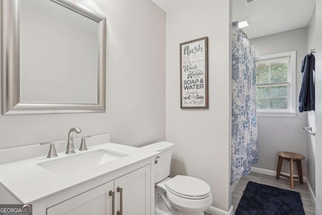 156 Sims St, Winder, GA 30680 - full bathroom featuring toilet, vanity, curtained shower, wood finished floors, and baseboards