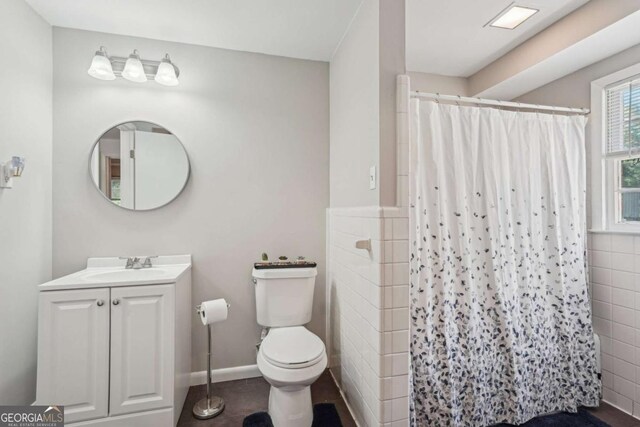 156 Sims St, Winder, GA 30680 - full bathroom featuring toilet, vanity, a shower with curtain, tile walls, and tile patterned floors