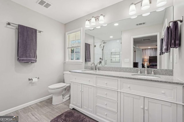 156 Sims St, Winder, GA 30680 - full bathroom featuring a stall shower, double vanity, toilet, wood finished floors, and baseboards