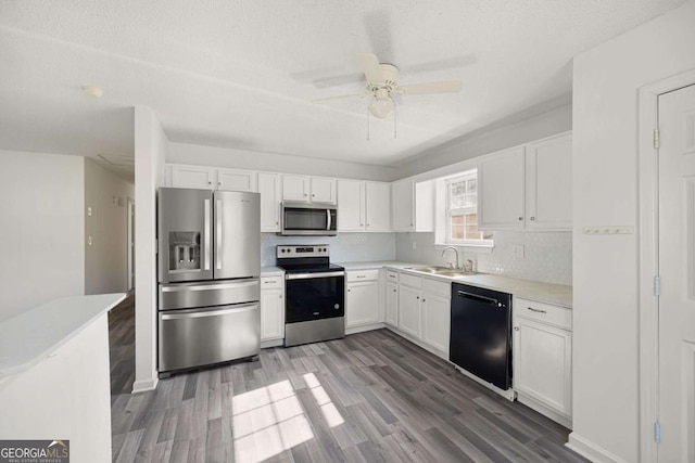 3645 Ten Oaks Cir, Powder Springs, GA 30127 - kitchen with appliances with stainless steel finishes, a sink, white cabinetry, wood finished floors, and a textured ceiling