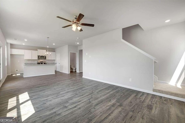 609 Lobelia Way, Locust Grove, GA 30248 - unfurnished living room with dark wood-style flooring, baseboards, ceiling fan, recessed lighting, and a chandelier