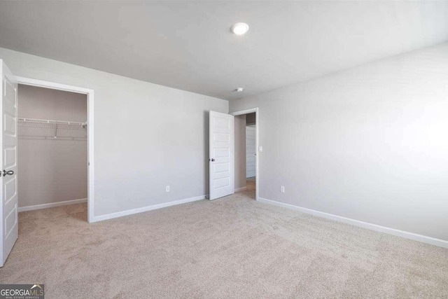 609 Lobelia Way, Locust Grove, GA 30248 - unfurnished bedroom featuring baseboards, carpet floors, a spacious closet, and a closet