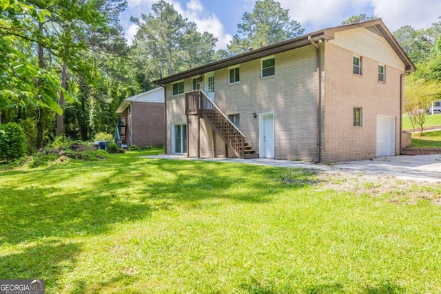 4345 Kimball Rd SW, Atlanta, GA 30331 - rear view of house with stairs, brick siding, an attached garage, and a yard