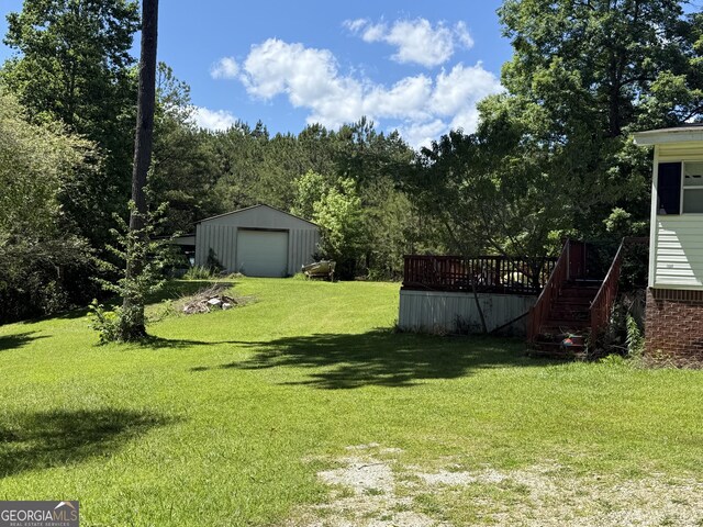 105 Hickory Crk, Bremen, GA 30110 - view of grassy yard featuring a detached garage, an outbuilding, a wooden deck, and stairs