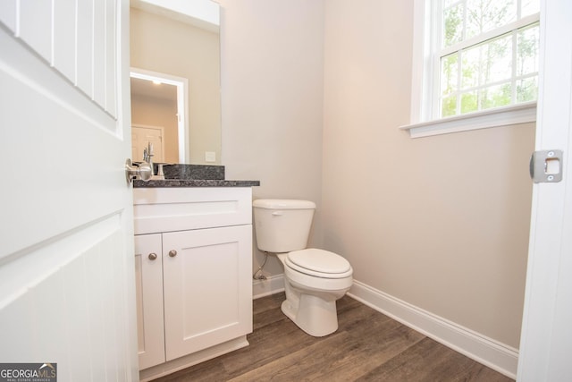 628 Grove St, Barnesville, GA 30204 - bathroom featuring baseboards, vanity, wood finished floors, and toilet