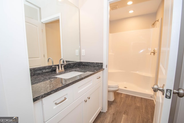 628 Grove St, Barnesville, GA 30204 - full bath featuring wood finished floors, toilet, vanity, and a shower