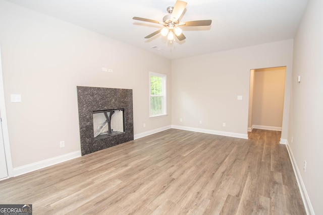628 Grove St, Barnesville, GA 30204 - unfurnished living room featuring wood finished floors, a premium fireplace, a ceiling fan, and baseboards