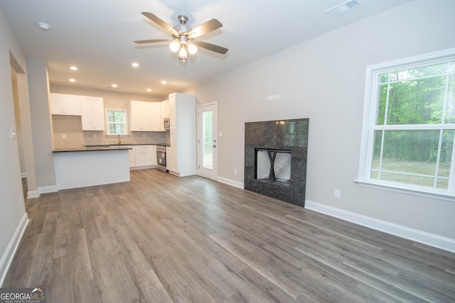 628 Grove St, Barnesville, GA 30204 - unfurnished living room featuring wood finished floors, a ceiling fan, a fireplace, baseboards, and recessed lighting
