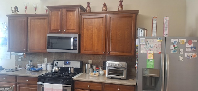 7314 Basalt Dr, Union City, GA 30291 - kitchen featuring appliances with stainless steel finishes, light countertops, backsplash, and brown cabinets