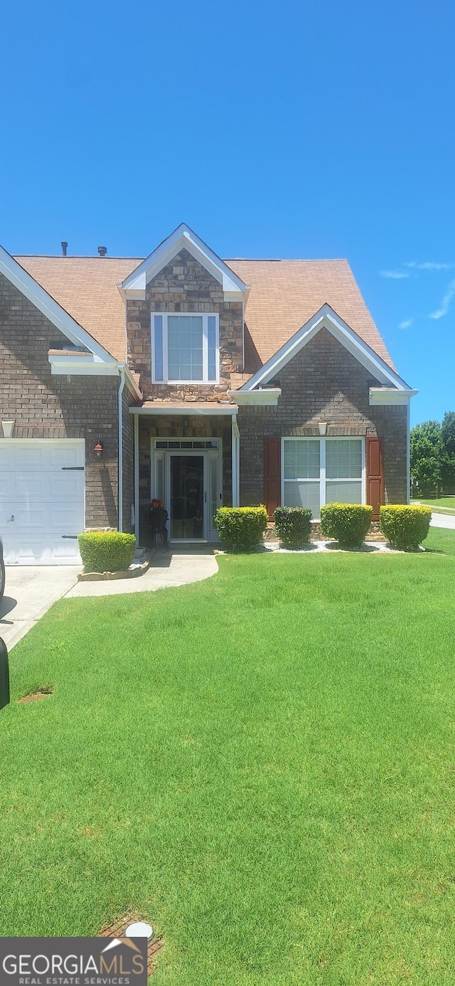7314 Basalt Dr, Union City, GA 30291 - view of front of home with a front lawn, an attached garage, stone siding, brick siding, and driveway