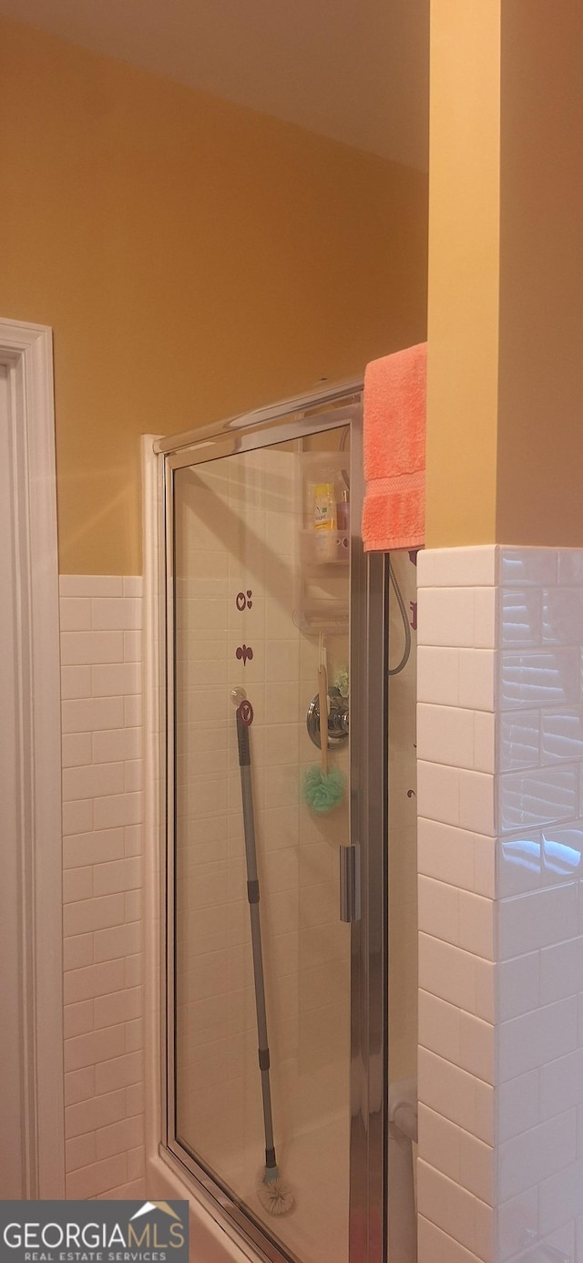 7314 Basalt Dr, Union City, GA 30291 - bathroom featuring a wainscoted wall, tile walls, and a stall shower