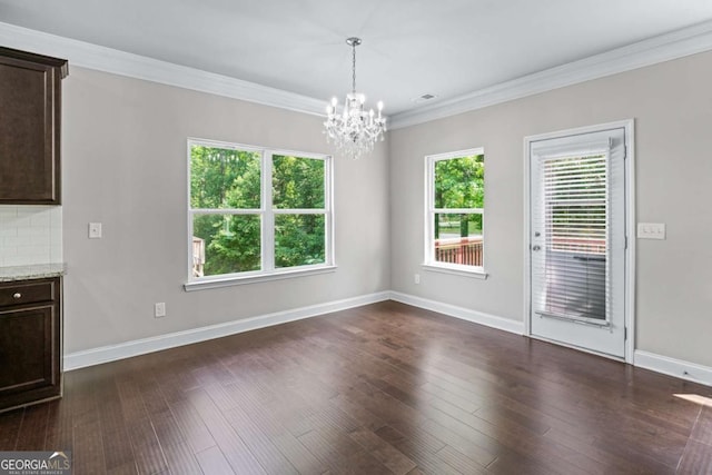 350 Paces Dr, Lithia Springs, GA 30122 - unfurnished dining area with a chandelier, crown molding, dark wood-type flooring, and baseboards