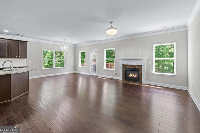 350 Paces Dr, Lithia Springs, GA 30122 - unfurnished living room with a chandelier, a premium fireplace, plenty of natural light, ornamental molding, and a sink