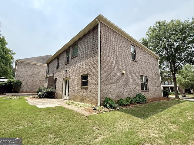 3389 Rosecliff Trce, Buford, GA 30519 - view of side of property featuring a lawn, a patio area, and brick siding