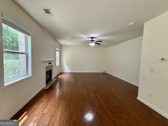 3389 Rosecliff Trce, Buford, GA 30519 - unfurnished living room featuring dark wood-style floors, a ceiling fan, a glass covered fireplace, and baseboards