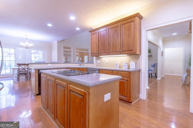 11389 Whitesville Rd, Fortson, GA 31808 - kitchen featuring a sink, a chandelier, brown cabinets, a kitchen island, and light wood-style floors