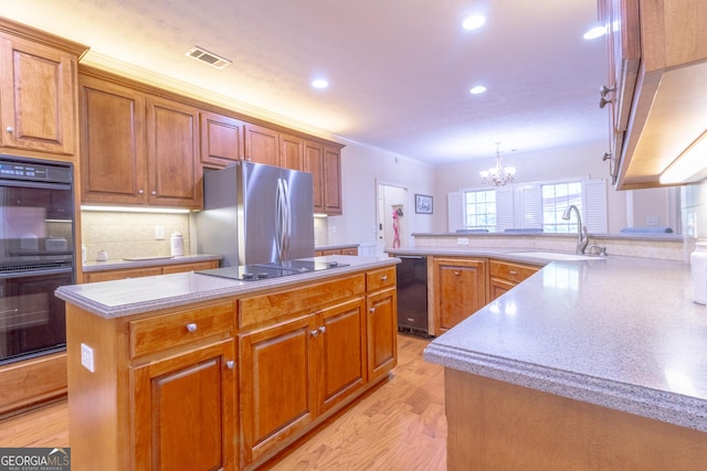 11389 Whitesville Rd, Fortson, GA 31808 - kitchen with black appliances, a sink, a kitchen island, a chandelier, and light wood-type flooring