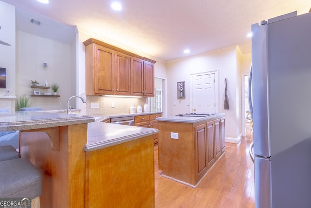 11389 Whitesville Rd, Fortson, GA 31808 - kitchen with freestanding refrigerator, a center island, brown cabinetry, crown molding, and light wood-style flooring