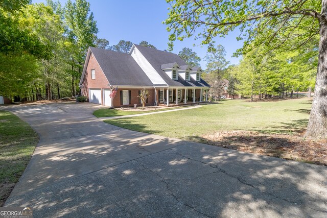 11389 Whitesville Rd, Fortson, GA 31808 - view of front of home featuring covered porch, a front lawn, concrete driveway, brick siding, and an attached garage