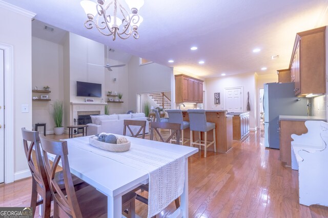 11389 Whitesville Rd, Fortson, GA 31808 - dining room featuring light wood finished floors, stairs, a fireplace, recessed lighting, and a chandelier