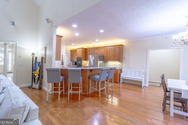 11389 Whitesville Rd, Fortson, GA 31808 - kitchen with freestanding refrigerator, a kitchen bar, a peninsula, recessed lighting, and light wood-style floors