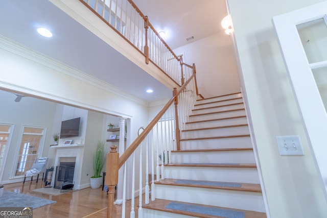 11389 Whitesville Rd, Fortson, GA 31808 - stairway with a fireplace with flush hearth, ornamental molding, wood finished floors, recessed lighting, and a high ceiling