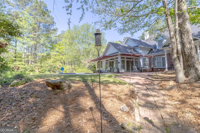 11389 Whitesville Rd, Fortson, GA 31808 - back of house featuring a sunroom, a patio area, and roof with shingles