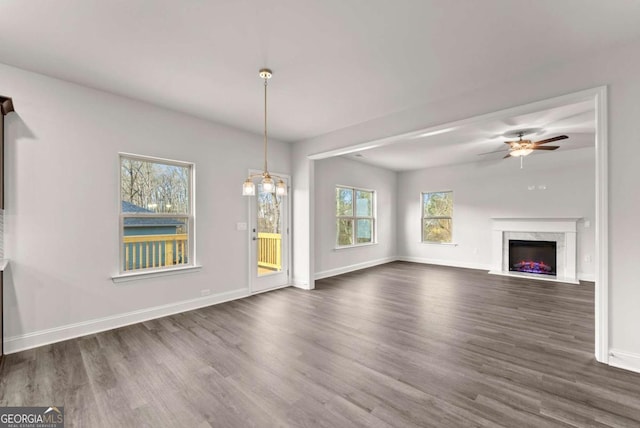 321 Magnolia Villas Dr, Cornelia, GA 30531 - unfurnished living room with dark wood-type flooring, baseboards, ceiling fan, and a high end fireplace