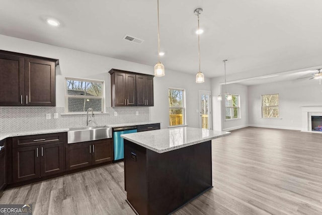 321 Magnolia Villas Dr, Cornelia, GA 30531 - kitchen with stainless steel dishwasher, a sink, light wood finished floors, dark brown cabinetry, and open floor plan