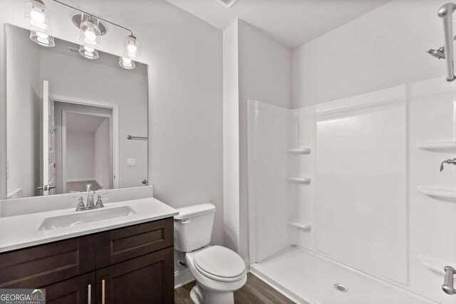 321 Magnolia Villas Dr, Cornelia, GA 30531 - full bathroom with wood finished floors, toilet, vanity, and a shower