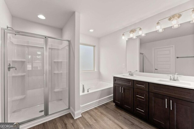 321 Magnolia Villas Dr, Cornelia, GA 30531 - bathroom with wood finished floors, a garden tub, a stall shower, double vanity, and recessed lighting