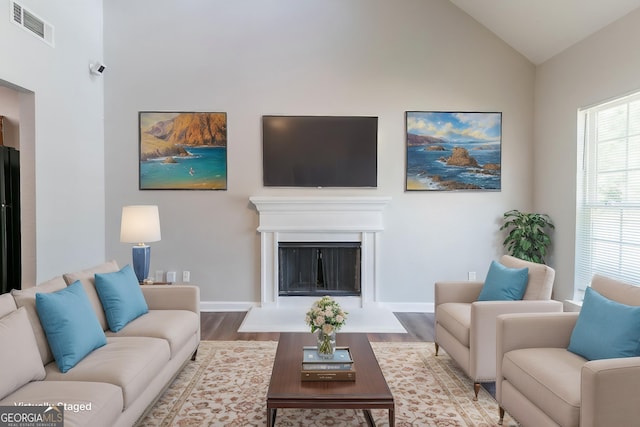 4695 Ravenwood Loop, Union City, GA 30291 - living area with wood finished floors, baseboards, vaulted ceiling, and a fireplace with flush hearth