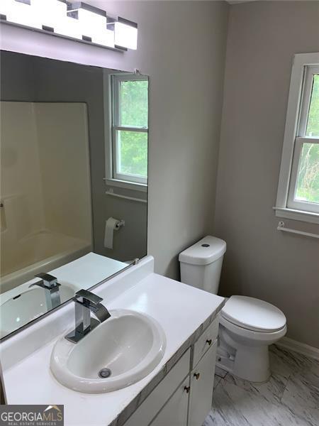 4347 Barrington Pl, Macon, GA 31210 - bathroom with vanity, healthy amount of natural light, toilet, and marble look tiles
