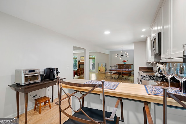 1560 Bubbling Creek Rd NE, Atlanta, GA 30319 - kitchen featuring stainless steel microwave, white cabinetry, a sink, light wood-style flooring, and recessed lighting