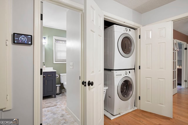 1560 Bubbling Creek Rd NE, Atlanta, GA 30319 - washroom with stacked washer and clothes dryer and light wood-type flooring