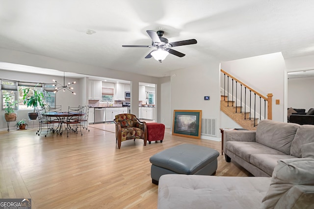 1560 Bubbling Creek Rd NE, Atlanta, GA 30319 - living area featuring ceiling fan, light wood-style floors, stairway, baseboards, and a chandelier
