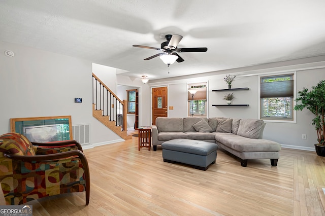 1560 Bubbling Creek Rd NE, Atlanta, GA 30319 - living room featuring light wood-style flooring, stairway, ceiling fan, and baseboards