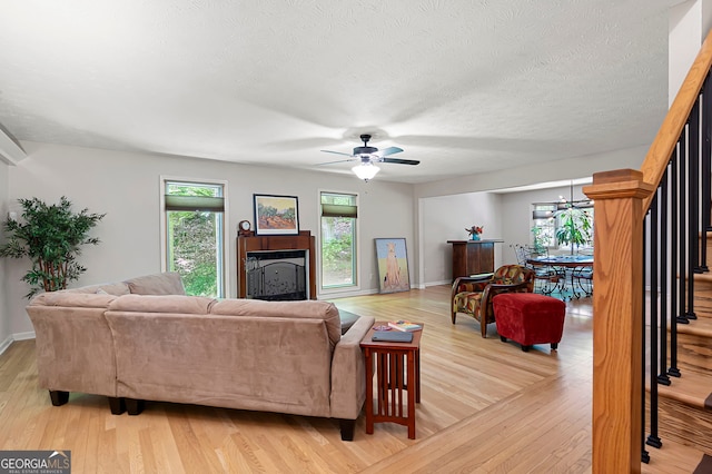 1560 Bubbling Creek Rd NE, Atlanta, GA 30319 - living area with a ceiling fan, light wood-style flooring, baseboards, a textured ceiling, and stairs