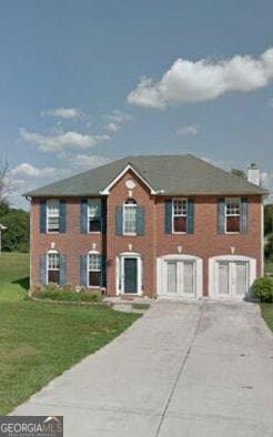 9066 Bob Jackson Dr, Jonesboro, GA 30238 - view of front of home with concrete driveway, a front lawn, and a chimney