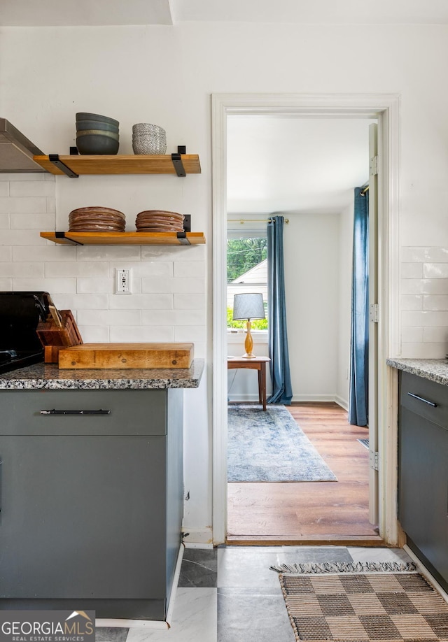 1682 Grace St SE, Atlanta, GA 30316 - kitchen featuring gray cabinets, tasteful backsplash, wood finished floors, light stone counters, and baseboards